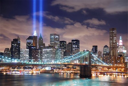 simsearch:400-04231799,k - Remember September 11. New York City Manhattan panorama view with Brooklyn Bridge at night with office building skyscrapers skyline illuminated over Hudson River and two light beam in memory of September 11. Foto de stock - Super Valor sin royalties y Suscripción, Código: 400-04240587