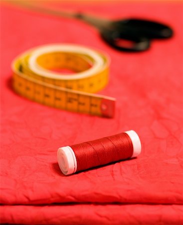 Yellow tape, bobbin  and scissors on the red fabric Stock Photo - Budget Royalty-Free & Subscription, Code: 400-04241185