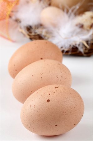 simsearch:400-04291976,k - Brown chicken eggs and Easter eggs with feathers in a nest on white background Photographie de stock - Aubaine LD & Abonnement, Code: 400-04242509