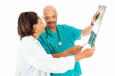 Attractive african-american doctors reviewing a patient's x-rays.  Isolated on white. Stock Photo - Budget Royalty-Free & Subscription, Code: 400-04242773