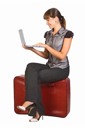Attractive girl sitting on suitcase with laptop on her hands Stock Photo - Budget Royalty-Free & Subscription, Code: 400-04243140