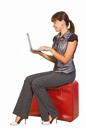Attractive girl sitting on suitcase with laptop on her hands Stock Photo - Budget Royalty-Free & Subscription, Code: 400-04243142