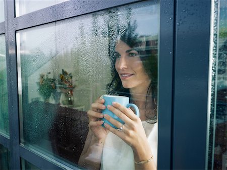 mid adult woman drinking coffee and looking out of the window on rainy day. Horizontal shape Stock Photo - Budget Royalty-Free & Subscription, Code: 400-04255110