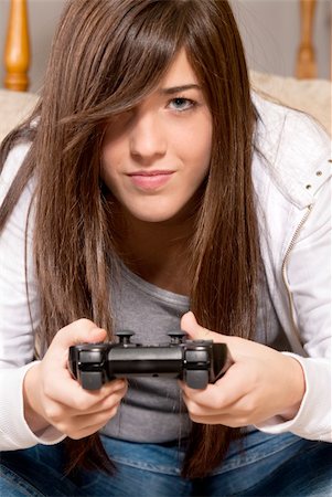 simsearch:400-05059261,k - Young female concentrating playing videogames close-up on sofa at home Stock Photo - Budget Royalty-Free & Subscription, Code: 400-04255378