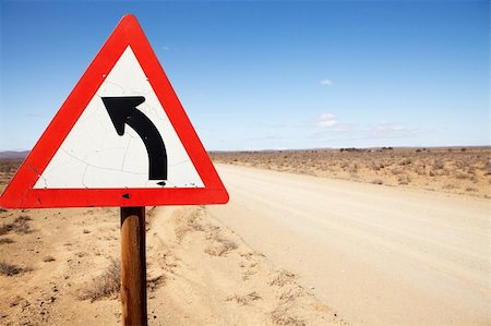 dry corrosion - Triangular road warning sign indicating road is turning left Stock Photo - Budget Royalty-Free & Subscription, Code: 400-04255708