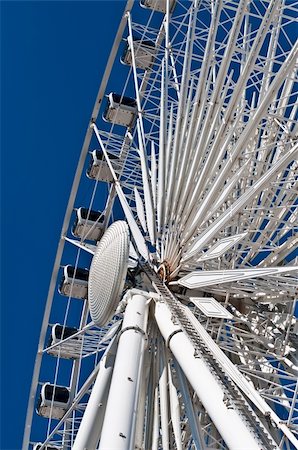 A large white ferris wheel with enclosed cars shot from below with a deep blue sky in the background. Stock Photo - Budget Royalty-Free & Subscription, Code: 400-04255895
