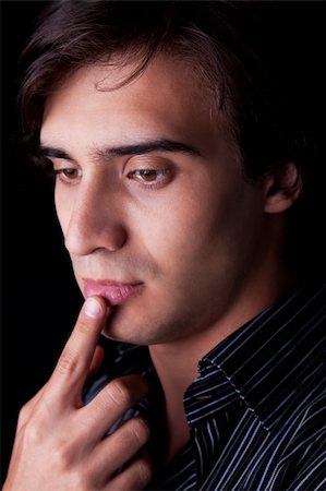 simsearch:400-07680948,k - Portrait of a handsome young man thinking, on black background. Studio shot Stock Photo - Budget Royalty-Free & Subscription, Code: 400-04256192