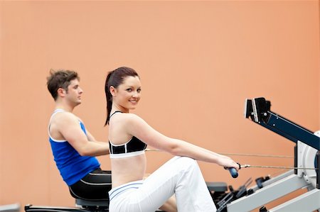 simsearch:400-04256139,k - Positive woman with her boyfriend using a rower in a sport centre Stock Photo - Budget Royalty-Free & Subscription, Code: 400-04256393