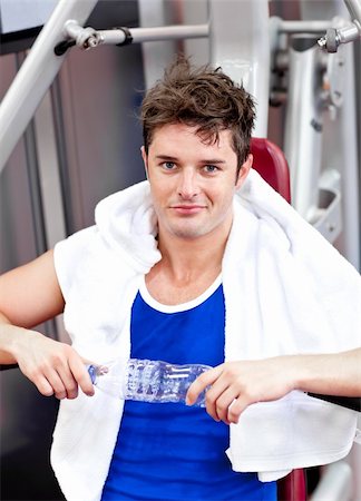 simsearch:400-05677914,k - Handsome athlete holding a bottle of water sitting on a bench press Stock Photo - Budget Royalty-Free & Subscription, Code: 400-04256418