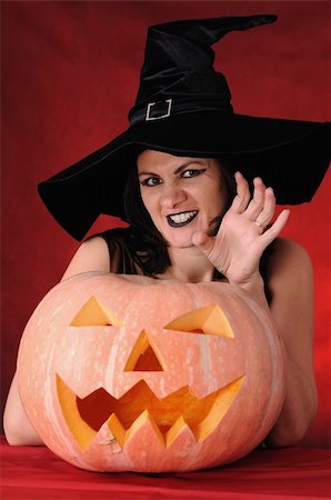 simsearch:400-06135836,k - Young witch with a pumpkin on a red background Stock Photo - Budget Royalty-Free & Subscription, Code: 400-04256513
