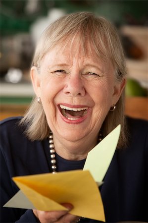 Senior woman at home reading greeting card Stock Photo - Budget Royalty-Free & Subscription, Code: 400-04256617