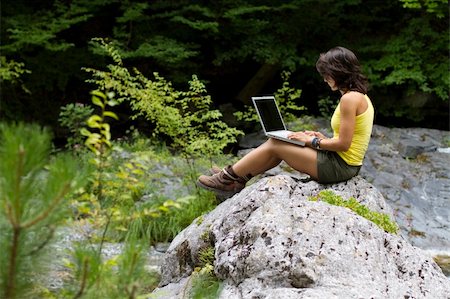 Girl with a laptop, sitting on a rock,  in the forest Foto de stock - Super Valor sin royalties y Suscripción, Código: 400-04256647