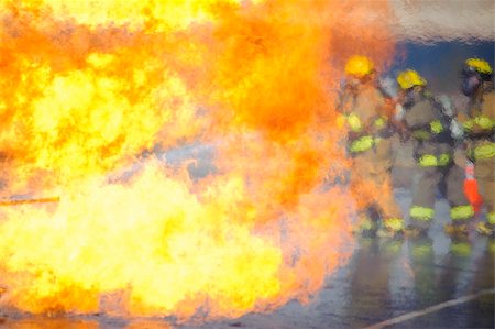 Heat waves partially obscure a team of firefighters preparing to attack a training fire. Stock Photo - Budget Royalty-Free & Subscription, Code: 400-04256677