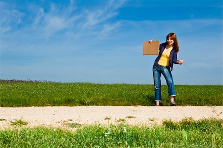 Young woman hitch hiking on a beautiful green meadow Stockbilder - Microstock & Abonnement, Bildnummer: 400-04256989