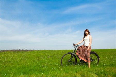 simsearch:400-04201795,k - Happy young woman with a vintage bicycle on a green meadow Fotografie stock - Microstock e Abbonamento, Codice: 400-04256992