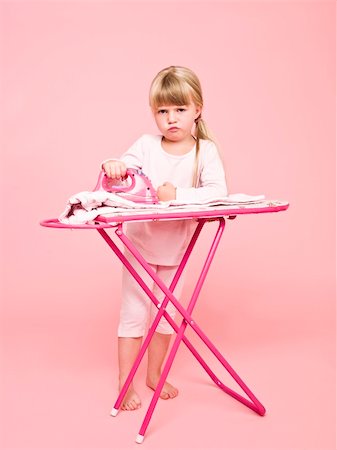 Angry girl ironing clothes towards pink background Stock Photo - Budget Royalty-Free & Subscription, Code: 400-04257288