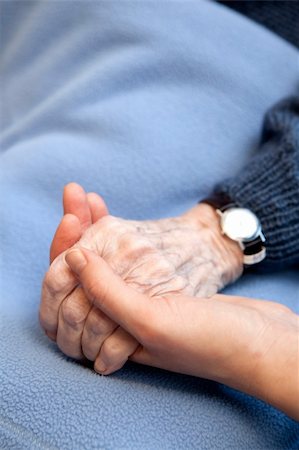 An old handing holding a young hand.  Shallow depth of field with focus on the hands. Stock Photo - Budget Royalty-Free & Subscription, Code: 400-04258465