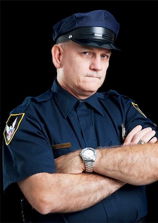 first responder - Portrait of a serious police officer with arms folded, against a black background. Stock Photo - Budget Royalty-Free & Subscription, Code: 400-04264512
