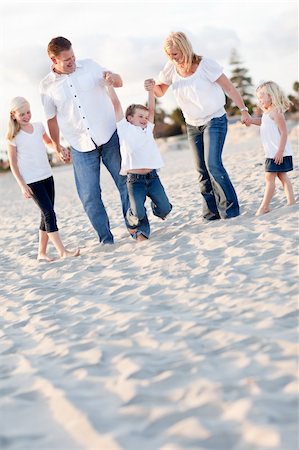 dad swinging kids at beach - Happy Young Boy Swinging with His Parents and Family at the Beach. Stock Photo - Budget Royalty-Free & Subscription, Code: 400-04264590