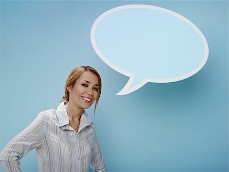person words speech bubble not phone not outdoors - mid adult business woman standing near blank speech bubble on blue background. Horizontal shape, front view, waist up, copy space Stock Photo - Budget Royalty-Free & Subscription, Code: 400-04266067