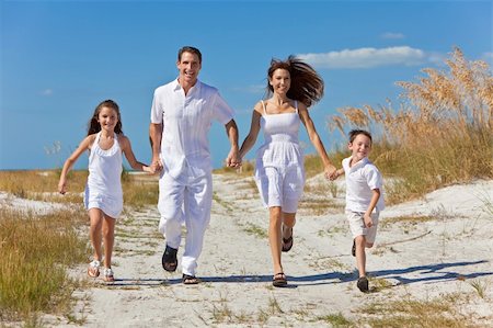 simsearch:400-04235471,k - A happy family of mother, father and two children, son and daughter, running holding hands and having fun in the sand of a sunny beach Stock Photo - Budget Royalty-Free & Subscription, Code: 400-04266210