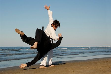 play fight - fighting of two men in taekwondo and apkido sports on the beach Foto de stock - Super Valor sin royalties y Suscripción, Código: 400-04266809