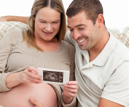 simsearch:400-04266844,k - Proud future dad looking at an echography with his wife in the living-room Stock Photo - Budget Royalty-Free & Subscription, Code: 400-04266846