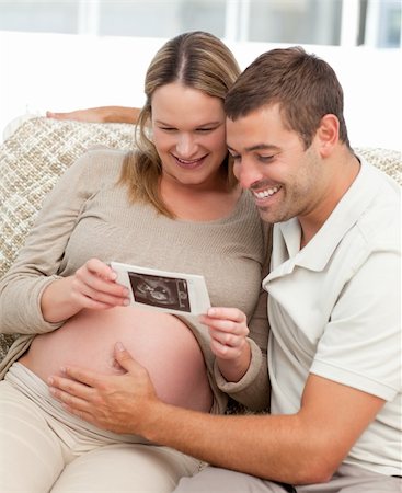 simsearch:400-04266840,k - Lovely couple looking at an echography while relaxing in the living-room Photographie de stock - Aubaine LD & Abonnement, Code: 400-04266847