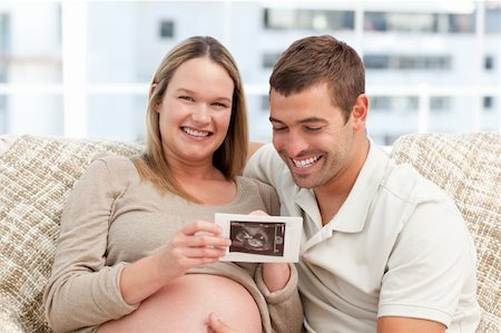 simsearch:400-04266844,k - Beautiful pregnant woman showing her echography to her husband at home Stock Photo - Budget Royalty-Free & Subscription, Code: 400-04266849