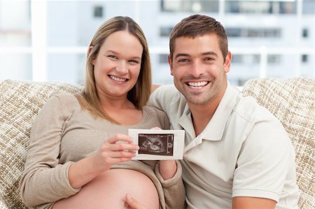 simsearch:400-04266844,k - Joyful future parents looking at an echography together on the sofa Stock Photo - Budget Royalty-Free & Subscription, Code: 400-04266850