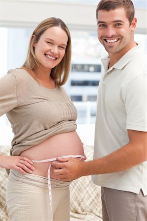 simsearch:400-04266844,k - Adorable future parents with a measuring tape in the living room Stock Photo - Budget Royalty-Free & Subscription, Code: 400-04266860