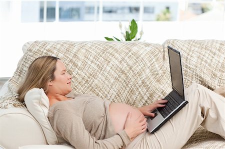 simsearch:400-04767824,k - Smiling pregnant woman using her laptop lying on the sofa at home Foto de stock - Royalty-Free Super Valor e Assinatura, Número: 400-04266894