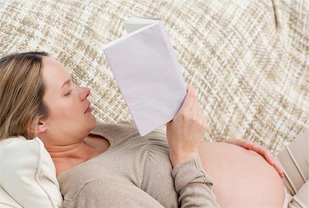 simsearch:400-04688796,k - Cute pregnant woman reading a book lying on the couch at home Fotografie stock - Microstock e Abbonamento, Codice: 400-04266892