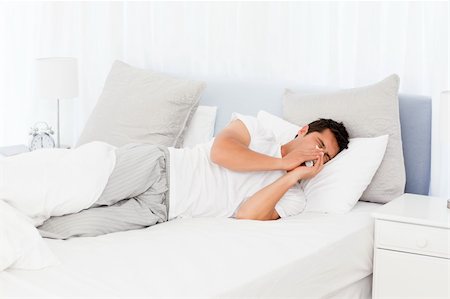 Sick man blowing his nose lying on his bed at morning Stock Photo - Budget Royalty-Free & Subscription, Code: 400-04266904