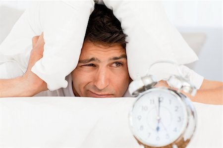 simsearch:400-04287303,k - Handsome man putting his head under the pillow lying on his bed Stock Photo - Budget Royalty-Free & Subscription, Code: 400-04266906