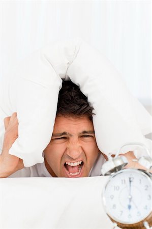 simsearch:400-04287303,k - Angry man with his head under the pillow lying on his bed Stockbilder - Microstock & Abonnement, Bildnummer: 400-04266907