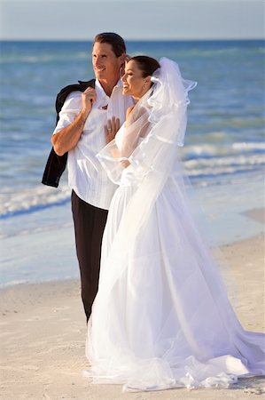 A married couple, bride and groom, together in sunshine on a beautiful tropical beach Foto de stock - Super Valor sin royalties y Suscripción, Código: 400-04267203