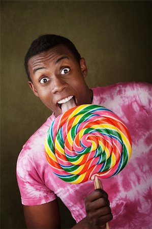 Young African-American man licking a giant lollipop Stock Photo - Budget Royalty-Free & Subscription, Code: 400-04267261