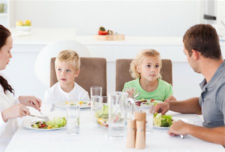 simsearch:400-04792006,k - Serious family eating a salad at lunch in the kitchen at home Stock Photo - Budget Royalty-Free & Subscription, Code: 400-04267325