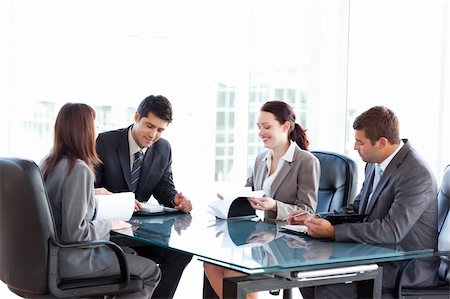 Four business people during a meeting sitting around a table Stock Photo - Budget Royalty-Free & Subscription, Code: 400-04267337