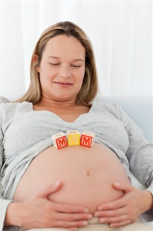 simsearch:400-04767824,k - Cute pregnant woman with mom letters on her belly relaxing on a bed Foto de stock - Royalty-Free Super Valor e Assinatura, Número: 400-04267361