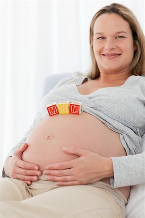 simsearch:400-04767824,k - Side view of a happy woman with mom letters on the belly lying on a bed Foto de stock - Royalty-Free Super Valor e Assinatura, Número: 400-04267370