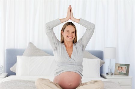 simsearch:400-04266869,k - Smiling pregnant woman doing yoga on the bed at home Stock Photo - Budget Royalty-Free & Subscription, Code: 400-04267373