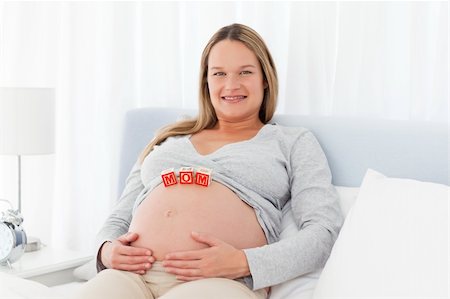 simsearch:400-04767824,k - Pregnant woman resting on a bed with mom letters on her belly Foto de stock - Royalty-Free Super Valor e Assinatura, Número: 400-04267396