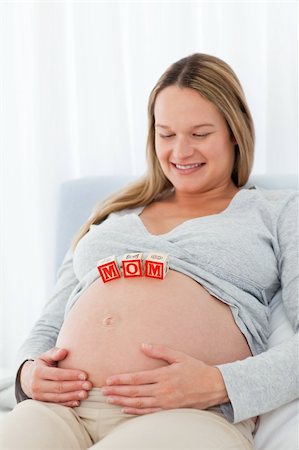 simsearch:400-04266869,k - Cute pregnant wife looking at mom letters on her belly while relaxing on a bed Stock Photo - Budget Royalty-Free & Subscription, Code: 400-04267392