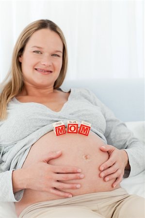 simsearch:400-04266869,k - Cheerful young woman with mom letters on her belly and looking at the camera Stock Photo - Budget Royalty-Free & Subscription, Code: 400-04267404