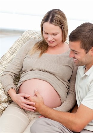 simsearch:400-04266844,k - Beautiful future parents feeling their unborn child sitting in the sofa at home Stock Photo - Budget Royalty-Free & Subscription, Code: 400-04267465