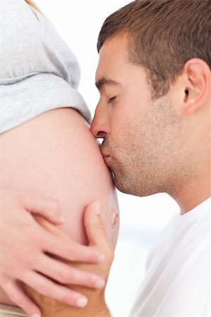 simsearch:400-04266840,k - Future father kissing the belly of his pregnant wife both in the bedroom Photographie de stock - Aubaine LD & Abonnement, Code: 400-04267460