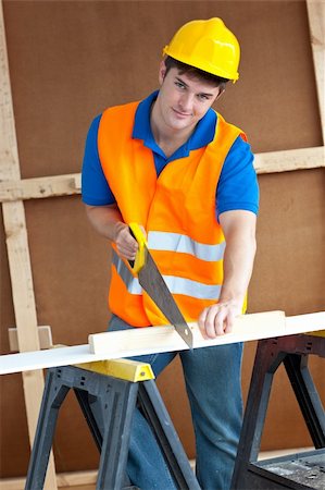 simsearch:400-05683356,k - Charismatic male worker wearing a yellow hardhat sawing a wooden board at work Stock Photo - Budget Royalty-Free & Subscription, Code: 400-04267470