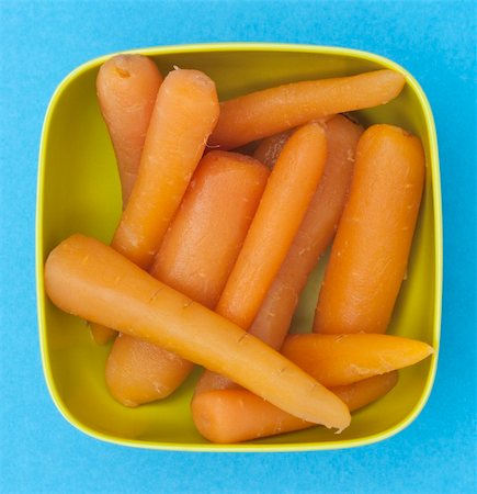 simsearch:400-04267736,k - Bowl of Canned Carrots on a Vibrant Blue Background. Fotografie stock - Microstock e Abbonamento, Codice: 400-04267734